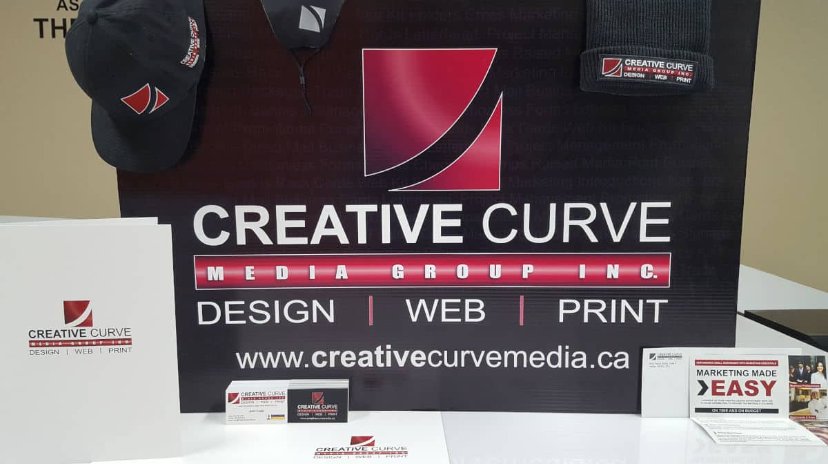 Creative Curve branded print item samples including kit folder, baseball hat, touque, face mask, envelope, business card, poster, and rack card